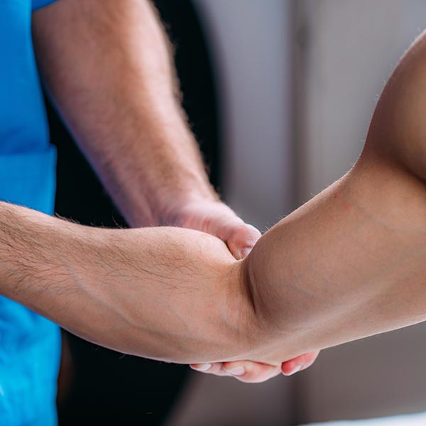 Doctor stretching out man's right arm during sports massage