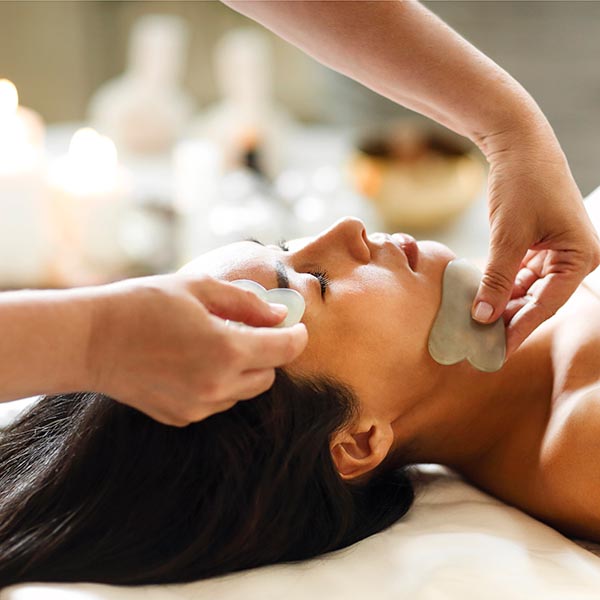 masseuse rubbing a woman's head during a relaxation massage