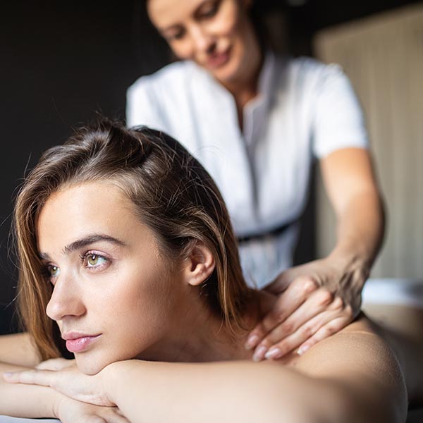 masseuse rubbing a woman's head during a relaxation massage
