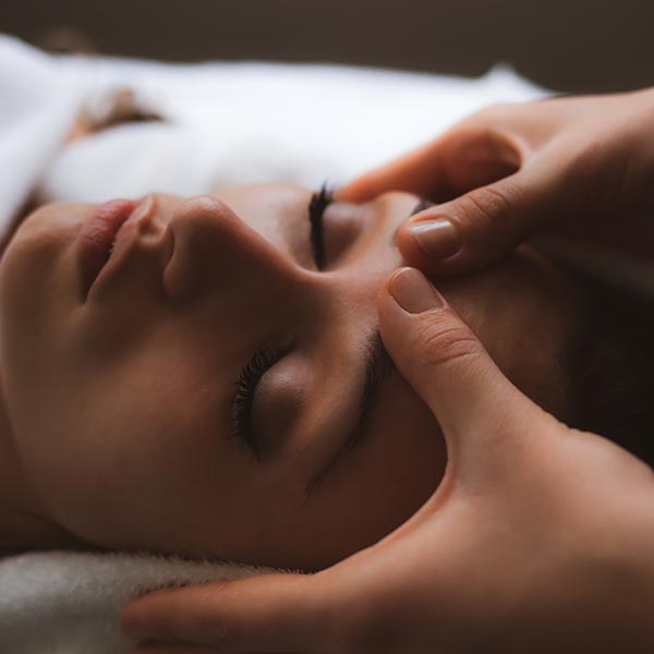 masseuse massaging a pregnant woman on massage table