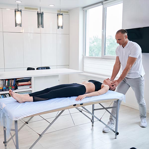 masseuse massaging a pregnant woman on massage table