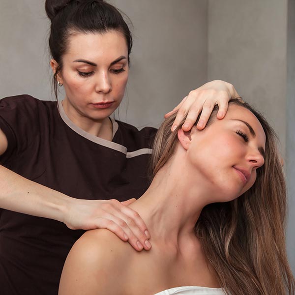masseuse massaging a pregnant woman on massage table