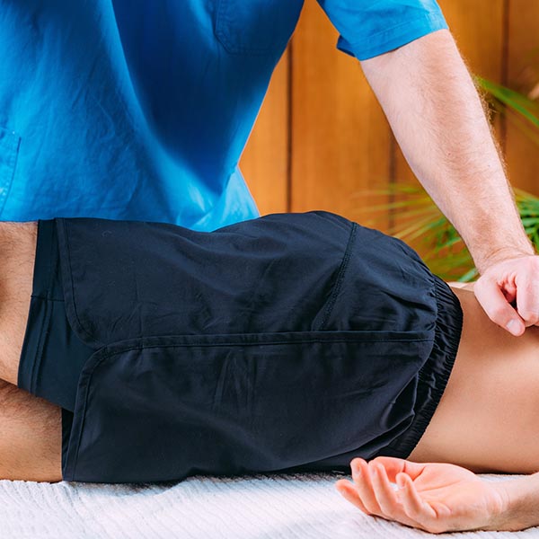 Doctor stretching out man's right arm during sports massage